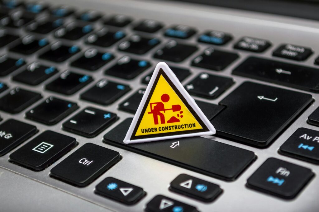 Current image: A miniature under construction sign placed on a laptop keyboard symbolizing digital development.